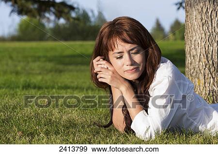 Stock Photo - Young woman spending personal time in a park; Edmonton, Alberta, Canada. Fotosearch