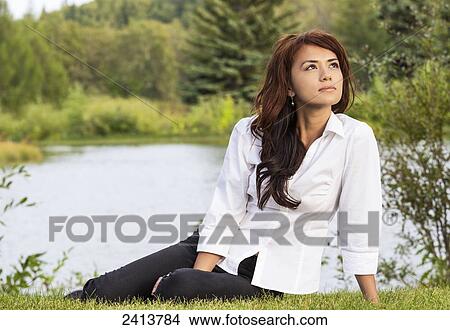 Young woman taking time for herself in a park; Edmonton, Alberta, Canada View Large Photo Image Picture - Young woman taking time for herself in a park; Edmonton, Alberta, Canada. Fotosearch