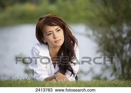 Stock Image - Young woman taking time for herself in a park; Edmonton, Alberta, Canada. Fotosearch