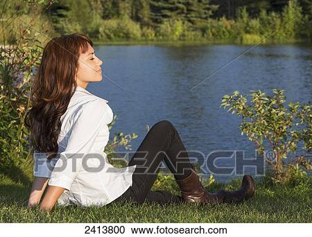 Young woman taking time for herself alone in a park; Edmonton, Alberta, Canada View Large Photo Image Stock Image - Young woman taking time for herself alone in a park; Edmonton, Alberta, Canada. Fotosearch