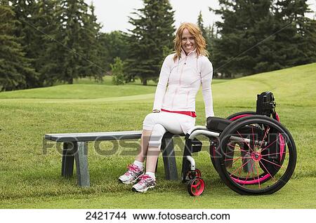 Picture - Young woman with spinal cord injury assisting with a golf tournament; Edmonton, Alberta, Canada. Fotosearch