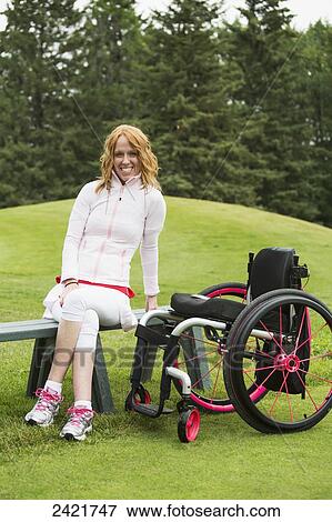 Young woman with spinal cord injury assisting with a golf tournament; Edmonton, Alberta, Canada View Large Photo Image Stock Photo - Young woman with spinal cord injury assisting with a golf tournament; Edmonton, Alberta, Canada. Fotosearch