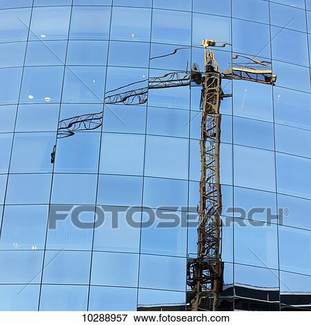 A crane reflected in the glass window facade of a building; Santiago, Santiago Metropolitan Region, Chile View Large Photo Image Stock Photo - A crane reflected in the glass window facade of a building; Santiago, Santiago Metropolitan Region, Chile. Fotosearch