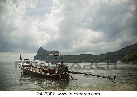 Stock Image - A fishing boat sits in the main bay of Koh Phi Phi Island in the Andaman Sea; Thailand. Fotosearch