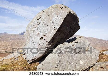 A large boulder balanced on another, near Molls Gap; County Kerry, Ireland View Large Photo Image Stock Image - A large boulder balanced on another, near Molls Gap; County Kerry, Ireland. Fotosearch