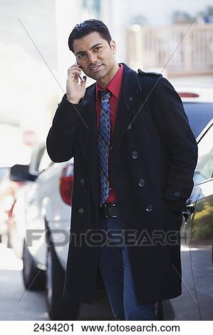 A man in a jacket and tie is standing by his car using his cell phone; San Francisco, California, United States of America View Large Photo Image Stock Image - A man in a jacket and tie is standing by his car using his cell phone; San Francisco, California, United States of America. Fotosearch