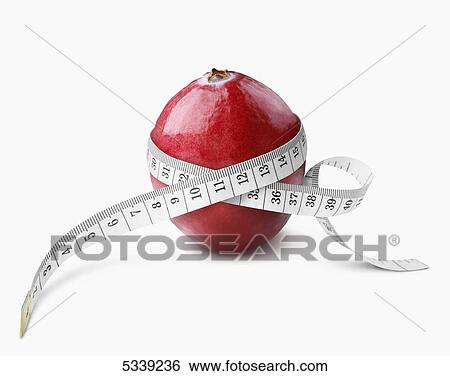 Stock Photograph - A measuring tape wrapped around a red piece of fruit. Fotosearch