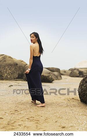 A model in formal dress walks barefoot on the sandy beach; Xiamen, China View Large Photo Image Picture - A model in formal dress walks barefoot on the sandy beach; Xiamen, China. Fotosearch