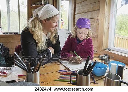 A mother with daughter writing in a tablet at a table in a cabin, Shoup Bay State Marine Park, Prince William Sound; Valdez, Alaska, United States of America View Large Photo Image Picture - A mother with daughter writing in a tablet at a table in a cabin, Shoup Bay State Marine Park, Prince William Sound; Valdez, Alaska, United States of America. Fotosearch