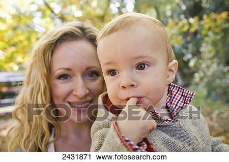 Stock Image - A mother with her baby boy in a park in autumn; Langley, British Columbia, Canada. Fotosearch