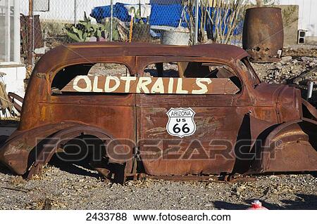Stock Photo - A rusted out antique car sits beside historic Route 66; Oatman, Arizona, United States of America. Fotosearch