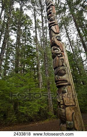 Stock Photo - A totem pole along the Totem Trail, surrounded by forest, Sitka National Historical Park; Sitka, Alaska, United States of America. Fotosearch