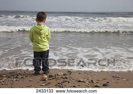 A young boy stands on the beach at the water's edge; South Shields, Tyne and Wear, England View Large Photo Image Stock Image - A young boy stands on the beach at the water's edge; South Shields, Tyne and Wear, England. Fotosearch
