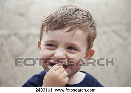 Stock Image - A young boy with a messy mouth while eating; South Shields, Tyne and Wear, England. Fotosearch