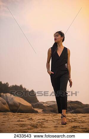 Stock Image - A young female model posing for a commercial picture on the coast; Xiamen, China. Fotosearch