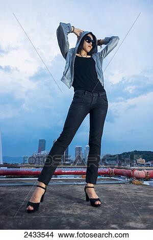A young female model posing on a roof at sunset; Xiamen, China View Large Photo Image Picture - A young female model posing on a roof at sunset; Xiamen, China. Fotosearch