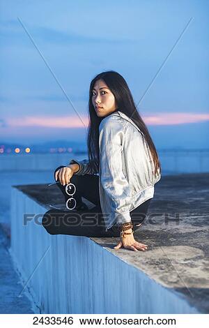 A young female model posing on a roof at sunset; Xiamen, China View Large Photo Image Stock Photograph - A young female model posing on a roof at sunset; Xiamen, China. Fotosearch