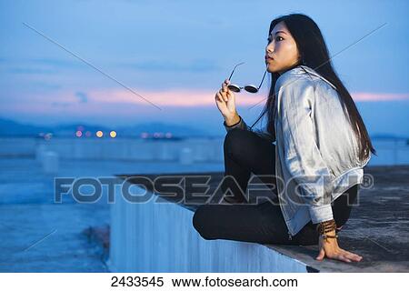 A young female model posing on a roof at sunset; Xiamen, China View Large Photo Image Stock Photography - A young female model posing on a roof at sunset; Xiamen, China. Fotosearch