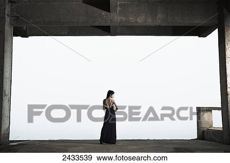 Stock Photo - A young female model stands posing for a commercial picture; Xiamen, China. Fotosearch