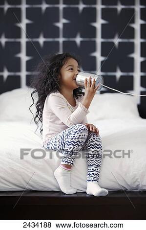 A young girl is playing with a can and string communication device; San Francisco, California, United States of America View Large Photo Image Stock Photo - A young girl is playing with a can and string communication device; San Francisco, California, United States of America. Fotosearch