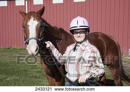Stock Image - A young woman posing with her horse at Eagle Mount; Bozeman, Montana, United States of America. Fotosearch