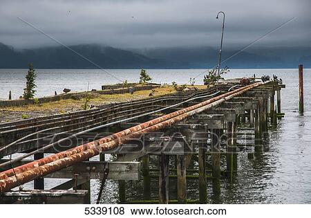 An old pier extends into the Columbia River; Astoria, Oregon, United States of America View Large Photo Image Stock Photo - An old pier extends into the Columbia River; Astoria, Oregon, United States of America. Fotosearch