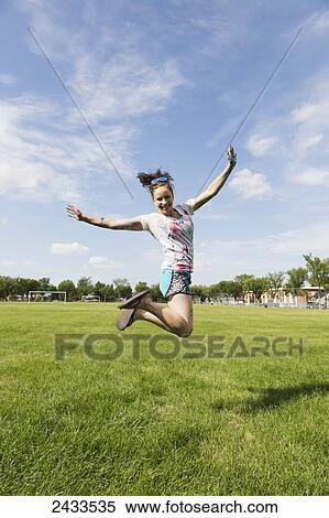 Stock Photography - Bridesmaid jumping in the air at Paint the Bride stagette party; Edmonton, Alberta, Canada. Fotosearch