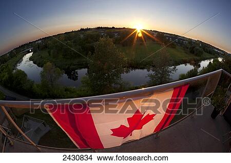Canada flag drapped over a balcony showing the Sturgeon River and sunset in background with fisheye lens; St. Albert, Alberta, Canada View Large Photo Image Picture - Canada flag drapped over a balcony showing the Sturgeon River and sunset in background with fisheye lens; St. Albert, Alberta, Canada. Fotosearch