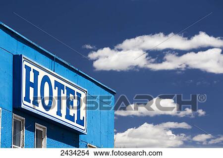 Close up of hotel sign on blue building with blue sky and clouds; Caresland, Alberta, Canada View Large Photo Image Picture - Close up of hotel sign on blue building with blue sky and clouds; Caresland, Alberta, Canada. Fotosearch