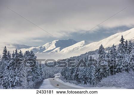 Clouds clearing over Seward Highway from the Kenai Mountains above Turnagain Pass after a winter snow storm, fresh snow in the trees, early morning sun, Turnagain Pass, Chugach National Forest, Southcentral Alaska, USA. View Large Photo Image Stock Image - Clouds clearing over Seward Highway from the Kenai Mountains above Turnagain Pass after a winter snow storm, fresh snow in the trees, early morning sun, Turnagain Pass, Chugach National Forest, Southcentral Alaska, USA.. Fotosearch