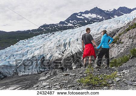 Couple standing on overlook in front of Shoup glacier, Shoup Bay State Marine Park, Prince William Sound; Valdez, Alaska, United States of America View Large Photo Image Stock Photo - Couple standing on overlook in front of Shoup glacier, Shoup Bay State Marine Park, Prince William Sound; Valdez, Alaska, United States of America. Fotosearch