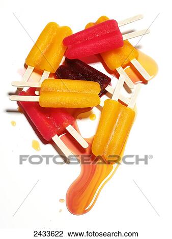 Stock Image - Different coloured popsicles melting. Fotosearch