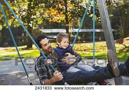 Stock Image - Father and son having fun together in a playground; Langley, British Columbia, Canada. Fotosearch