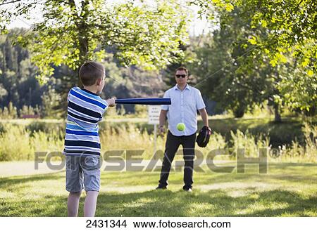 Father and son playing baseball in a park; Edmonton, Alberta, Canada View Large Photo Image Picture - Father and son playing baseball in a park; Edmonton, Alberta, Canada. Fotosearch