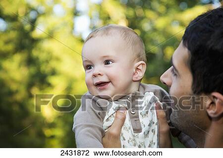 Father holding his young son outdoors in autumn; Edmonton, Alberta, Canada View Large Photo Image Stock Image - Father holding his young son outdoors in autumn; Edmonton, Alberta, Canada. Fotosearch