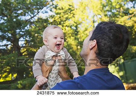 Stock Photography - Father holding his young son outdoors in autumn; Edmonton, Alberta, Canada. Fotosearch