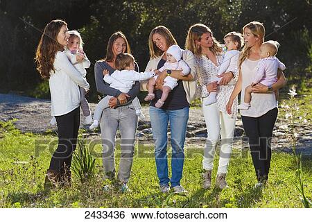 Stock Photograph - Five mothers holding baby daughters; Tarifa, Cadiz, Andalusia, Spain. Fotosearch