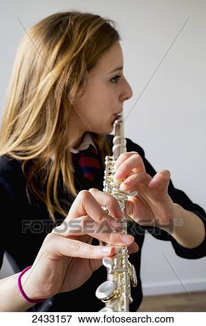 Stock Photo - Girl playing flute wearing school uniform; England. Fotosearch