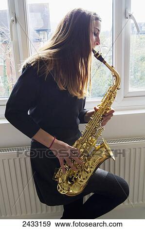 Girl playing saxophone in school uniform; England View Large Photo Image Stock Photo - Girl playing saxophone in school uniform; England. Fotosearch