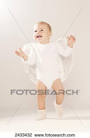 Stock Image - Happy baby with wings; Tarifa, Cadiz, Andalusia, Spain. Fotosearch