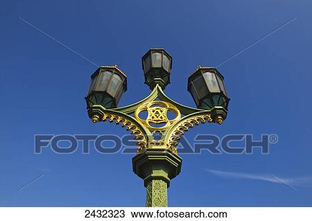 Stock Image - Low angle view of an ornate lamp post against a blue sky; London, England. Fotosearch