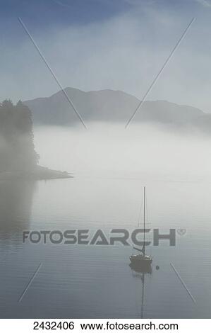 Low fog and mist burn off along the shoreline in Alaska's Inside Passage where a sailboat rests at anchor in a small cove near Juneau, Alaska. Tongass National Forest. View Large Photo Image Stock Photograph - Low fog and mist burn off along the shoreline in Alaska's Inside Passage where a sailboat rests at anchor in a small cove near Juneau, Alaska. Tongass National Forest.. Fotosearch