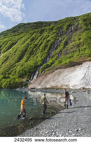 Man with two teenage boys on the beach in front of green mountain with waterfall at Shoup Bay State Marine Park, Prince William Sound; Valdez, Alaska, United States of America View Large Photo Image Stock Photography - Man with two teenage boys on the beach in front of green mountain with waterfall at Shoup Bay State Marine Park, Prince William Sound; Valdez, Alaska, United States of America. Fotosearch