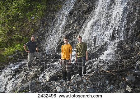Man with two teenage boys on the rocks in front of a waterfall at Shoup Bay State Marine Park, Prince William Sound; Valdez, Alaska, United States of America View Large Photo Image Stock Photograph - Man with two teenage boys on the rocks in front of a waterfall at Shoup Bay State Marine Park, Prince William Sound; Valdez, Alaska, United States of America. Fotosearch