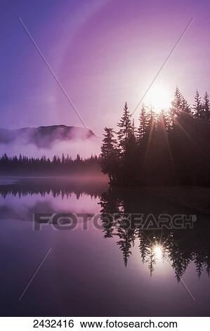 Stock Photograph - Morning fog clears off Mendenhall Lake, Tongass National Forest, Juneau, Alaska.. Fotosearch