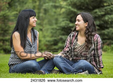 Mother and daughter talking together on grass; Sherwood Park, Alberta, Canada View Large Photo Image Stock Photograph - Mother and daughter talking together on grass; Sherwood Park, Alberta, Canada. Fotosearch