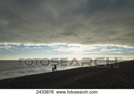 Mother and daughter walking along beach; Aldeburgh, Suffolk, England View Large Photo Image Stock Photo - Mother and daughter walking along beach; Aldeburgh, Suffolk, England. Fotosearch