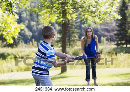 Mother and son playing baseball outdoors in a park; Edmonton, Alberta, Canada View Large Photo Image Picture - Mother and son playing baseball outdoors in a park; Edmonton, Alberta, Canada. Fotosearch