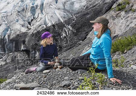 Mother and young daughter with a stuffed animal sitting on some rocks in front of Shoup glacier, Shoup Bay State Marine Park, Prince William Sound; Valdez, Alaska, United States of America View Large Photo Image Stock Photograph - Mother and young daughter with a stuffed animal sitting on some rocks in front of Shoup glacier, Shoup Bay State Marine Park, Prince William Sound; Valdez, Alaska, United States of America. Fotosearch