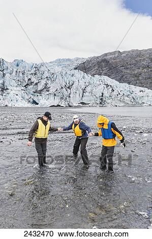 Mother with two teenage sons wearing life jackets, crossing a stream in front of Shoup glacier and Chugach mountains, Shoup Bay State Marine Park, Prince William Sound; Valdez, Alaska, United States of America View Large Photo Image Stock Image - Mother with two teenage sons wearing life jackets, crossing a stream in front of Shoup glacier and Chugach mountains, Shoup Bay State Marine Park, Prince William Sound; Valdez, Alaska, United States of America. Fotosearch